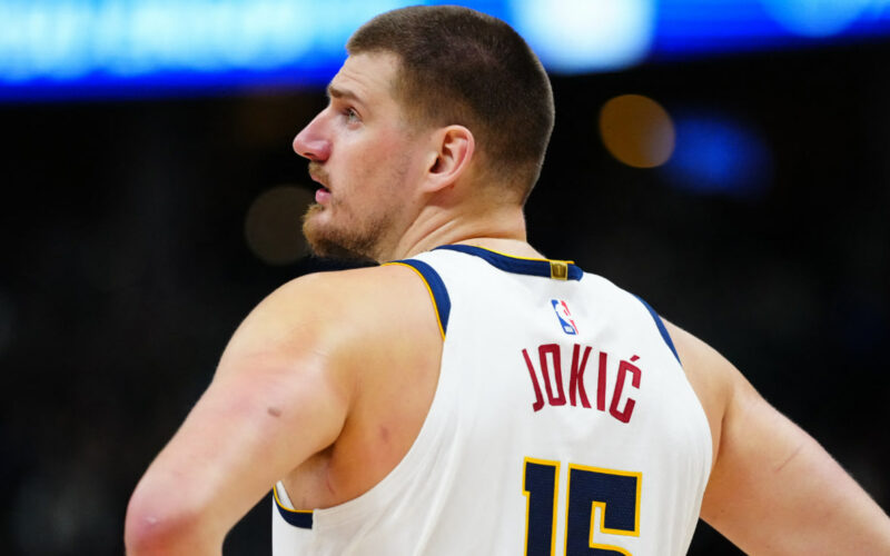 Ilustrasi Nikola Jokić sedang melakukan passing cerdas dalam pertandingan NBA.